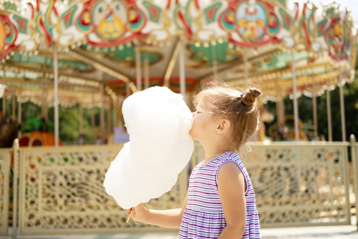 Hire candy floss machine — girl enjoying cotton candy at fun fair for parties and events in Johannesburg, Sandton and Randburg