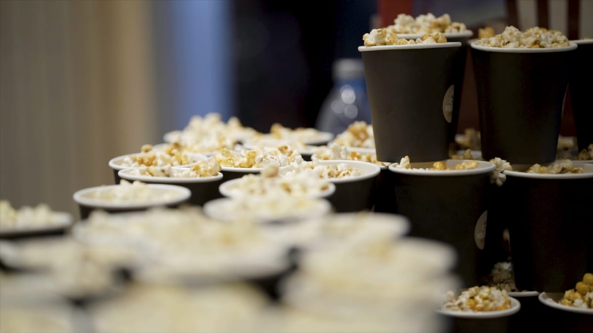 Hire popcorn machine — caramel popcorn in striped buckets on a wooden table for party catering hire